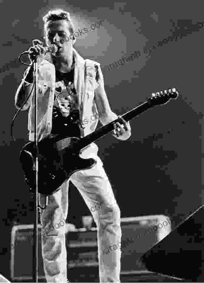 A Black And White Photograph Capturing The Clash In Their Early Days, With Joe Strummer Holding His Guitar And Singing With Intense Passion. Stealing All Transmissions: A Secret History Of The Clash